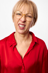 Fototapeta premium Woman senior portrait, glasses, laughter, blonde hair, red shirt, studio shot on white background, smiling face, cheerful expression, closeup headshot, friendly mood