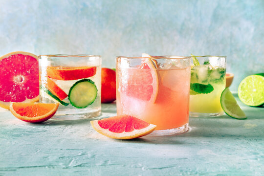 Refreshing summer cocktails with ice cubes on a light background