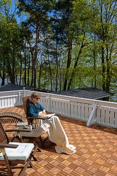 erkner, deutschland - eine frau erholt sich auf ihrem balkon