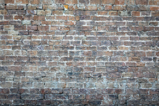 Aged weathered brick wall texture background with rustic urban masonry detail