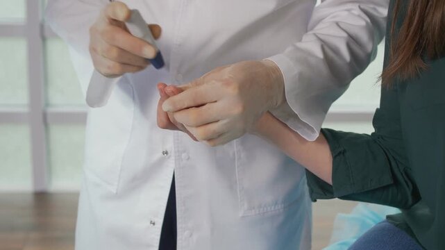 Close-up of blood glucose monitoring using a finger prick test and portable glucometer. Diabetes management, blood sugar control, healthcare diagnostics, and preventive medical care concept.