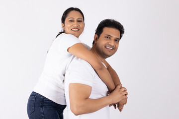Obraz premium Indian happy young loving couple embracing isolated on white. Couple wearing white t-shirt with happy moment, harmonic relationships, love making care and enjoying weekend time together, copy space