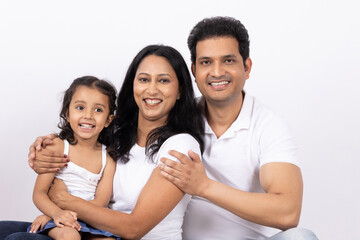Obraz premium Indian happy beautiful family. Indian happy family of a father, mother and daughter standing together on a white background.