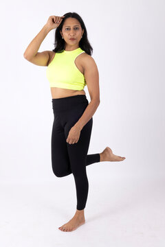 Indian Young slim woman in white sportwear on white background. Slim fit female with flat belly. Body care, healthy and sporty life