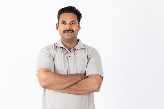 Portrait of indian young happy man arm crossed 
on white background