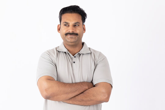 Portrait of indian young happy man arm crossed 
on white background