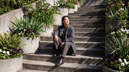 Obraz premium Seated Editorial Portrait On Brutalist Garden Stairs With Floral Masses
