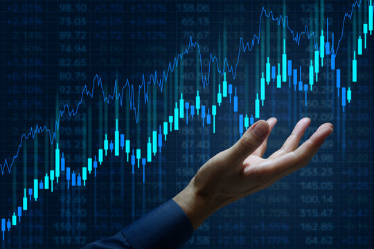 Stock market trading charts and analysis of high growth investment opportunities. Bull market trend. Investor holding candlestick chart.