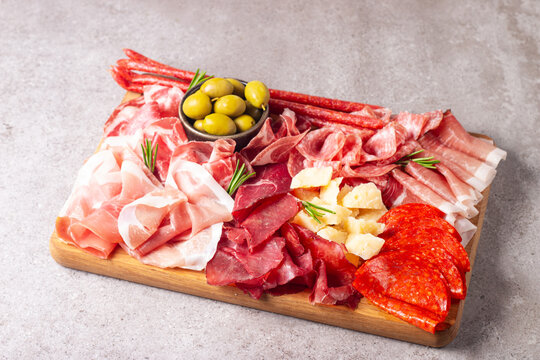 Italian Charcuterie board. Antipasti appetizers of meat platter with salami, prosciutto crudo or jamon and olives