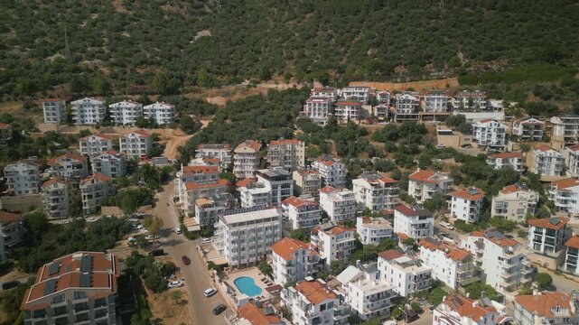 Drone shot of coastal real estate and residential houses on green slope