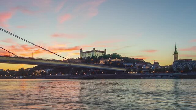 Day to night hyper lapse Bratislava old town and SNP bridge over of calm Danube river. Slovakia.