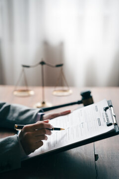 Lawyer reviewing legal documents with a gavel and scales, symbolizing justice, legal services, contracts, and court proceedings.