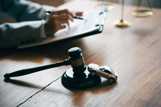 Judge's gavel and model car on a desk, representing vehicle auctions, legal disputes, insurance claims, and automotive law.