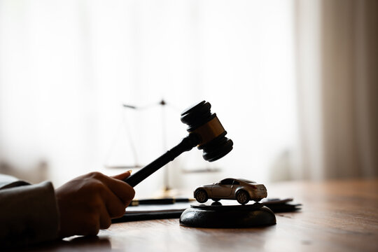 Judge's gavel and model car on a desk, representing vehicle auctions, legal disputes, insurance claims, and automotive law.