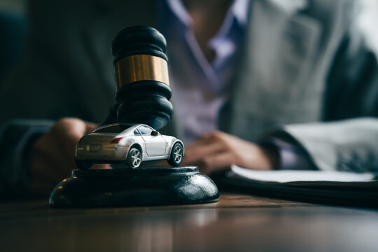 Judge's gavel and model car on a desk, representing vehicle auctions, legal disputes, insurance claims, and automotive law.