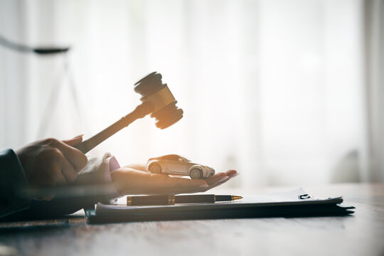 Judge's gavel above a model car, symbolizing vehicle auctions, legal disputes, insurance claims, and automotive law.
