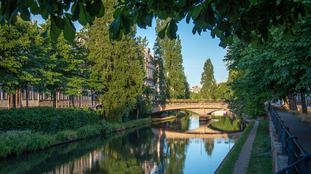 Promenade pi&eacute;tonne le long des berges bord&eacute;es d'arbres du canal du Faux-Rempart, d&eacute;rivation de la rivi&egrave;re Ill, dans le centre de la ville de Strasbourg, France