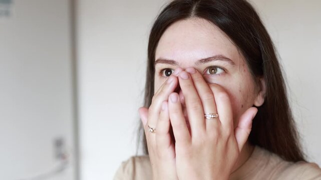 Young Caucasian woman applies serum and massages face. Close up slow motion shows skincare routine for problem skin. Healthy beauty care concept.