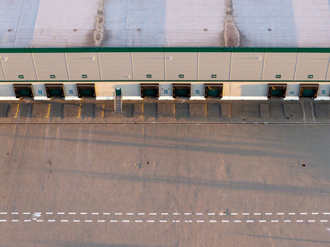 Aerial view of a distribution warehouse with loading docks and a large paved yard in Piorunow, Masovian Voivodeship, Poland.