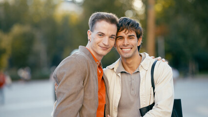 Fototapeta premium Happy gay couple posing outdoors, embracing and smiling, representing love, diversity, and an authentic relationship