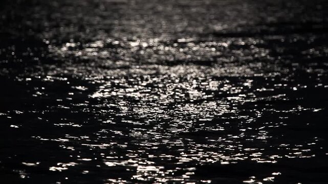 Abstract background of shimmering moonbeams on rolling ocean waves