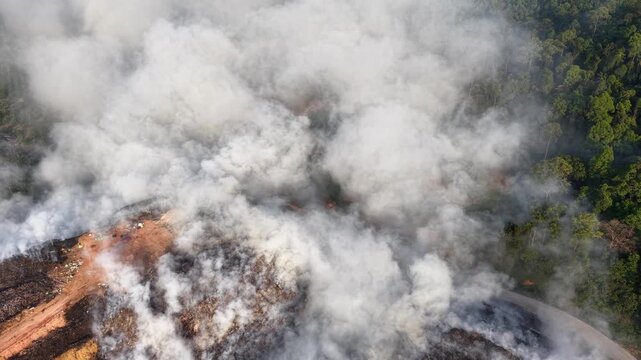 Aerial drone view of fire burning at landfill site