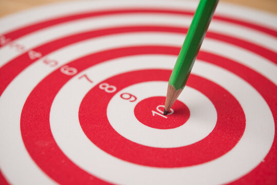 Closeup red pencil hit to the center of dartboard. Success target in the education, graduated from university, high score or pass the examination, get a scholarship, get the good job and so on concept