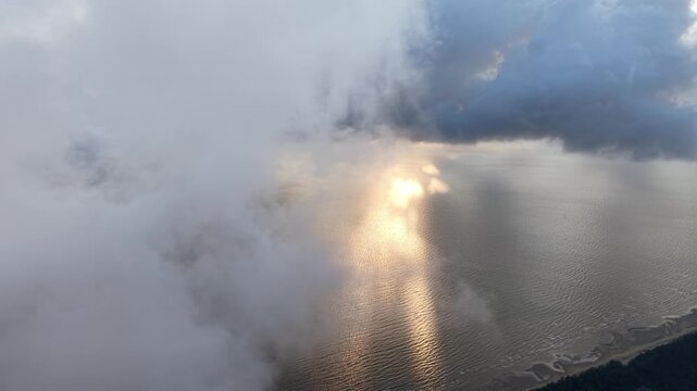 Sunlight pierces storm clouds over the ocean