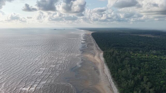 Wide aerial view of sandy coast meets ocean waves