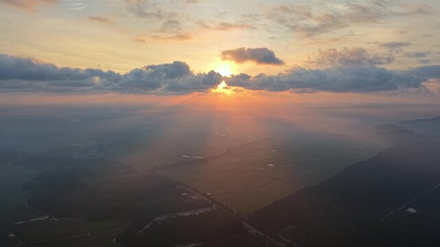 Aerial view captures golden sunburst through clouds