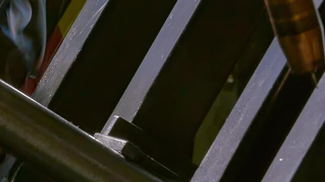 Watch the mesmerizing slow motion of a robotic arm as it expertly performs argon welding. Sparks fly and smoke curls in an industrial setting, showcasing precision and artistry in every movement.
