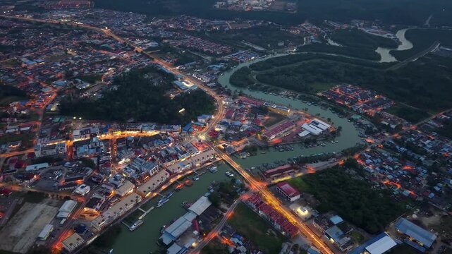 Aerial city view glows at dusk along a river