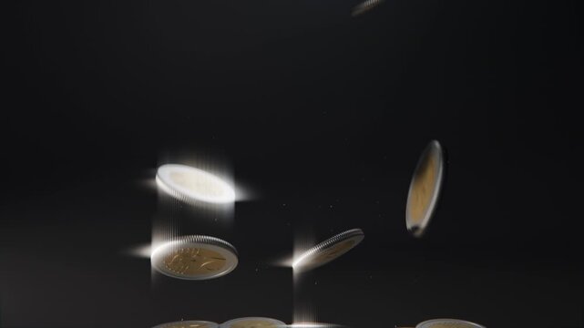 Dropping bimetal coins tumbling and spinning in dark studio with key light, creating scattered pile
