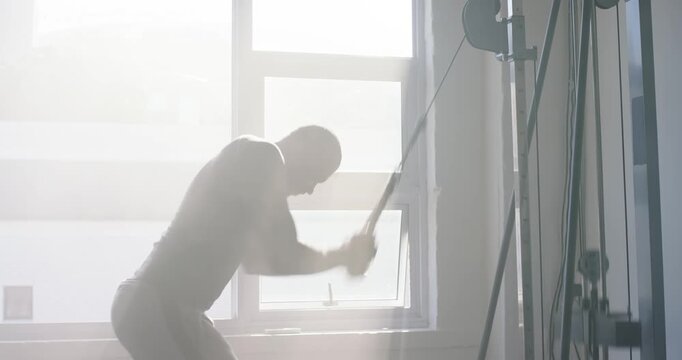African American man gripping rope doing cable rows in gym wearing fitted gear building strength