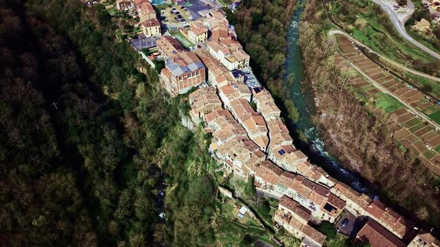 Aerial panorama of Castellfollit de la Roca perched on volcanic cliff in Spain.