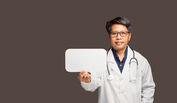 Woman in medical coat holding blank sign in studio