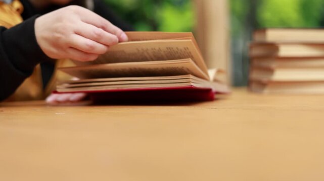 Young woman reading open book on desk. Student enjoying education and literature study. Academic learning process at home or library. Knowledge development, research and hobby concept.