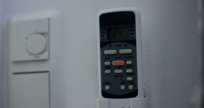 Close up of a man using a brass touchless tool to pull open a white indoor door handle