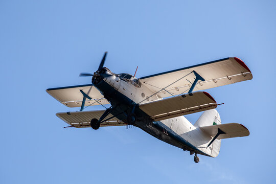 Vintage Antonov An-2 Biplane Flying Against Clear Blue Sky, Classic Soviet Era Propeller Aircraft in Flight, Retro Aviation Photography
