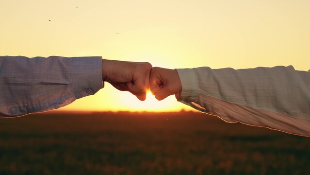 Man, woman greet each other with fist bump. Fist bump sign agreement, gesture respect. Close-up business team fists. Trust, understanding, teamwork. Fists against sky sun, trust, harmony, friendship