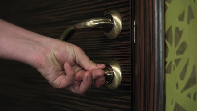 Close-up of a hand opening and closing the door latch