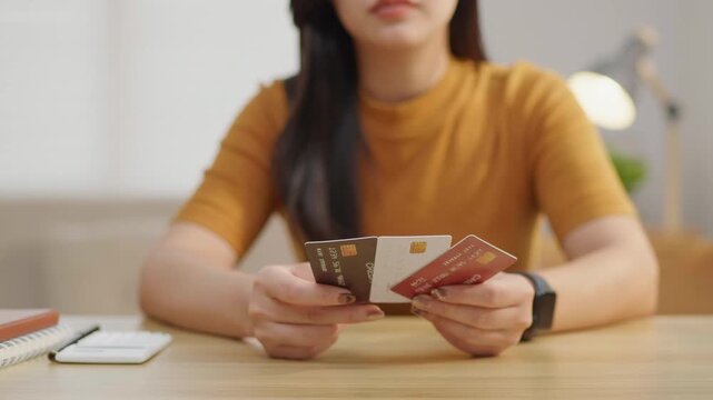 Woman holding multiple credit cards, ideal for personal finance, banking, card choices, consumer spending, budgeting and payment method concepts.