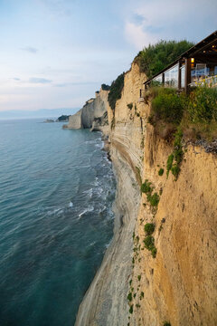 A serene and majestic view of the golden cliffs at Logas Beach in Corfu, evoking a deep sense of peaceful isolation, romantic wanderlust, and the calming beauty of a Mediterranean sunset escape.