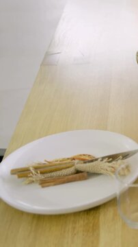 Vertical video: Panning camera from white plate with dried citrus, pulling back to reveal interior