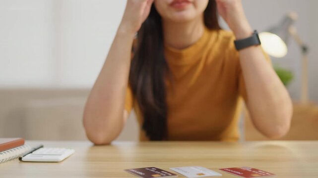 Woman stressed while holding multiple credit cards, ideal for debt, overspending, budgeting, money anxiety, financial pressure and personal finance problem concepts.