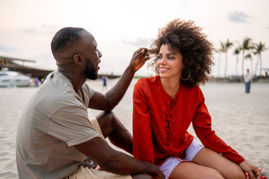 Happy couple enjoys the pure joy of life while relaxing on a tropical beach at dusk