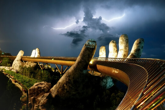 A bright flash of lightning and thunderclaps over the mountains in the sky at night, Golden Bridge in Ba Na hills, Da Nang, Vietnam