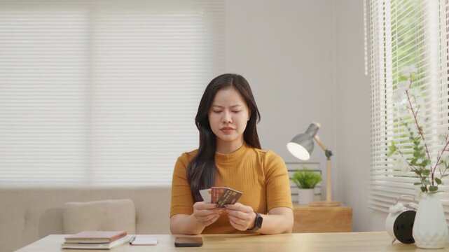 Woman stressed while holding multiple credit cards, ideal for debt, overspending, budgeting, money anxiety, financial pressure and personal finance problem concepts.