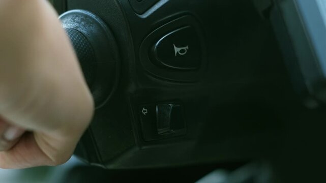 Close-up of hand pressing the turn signal switch on the motorcycle handlebar