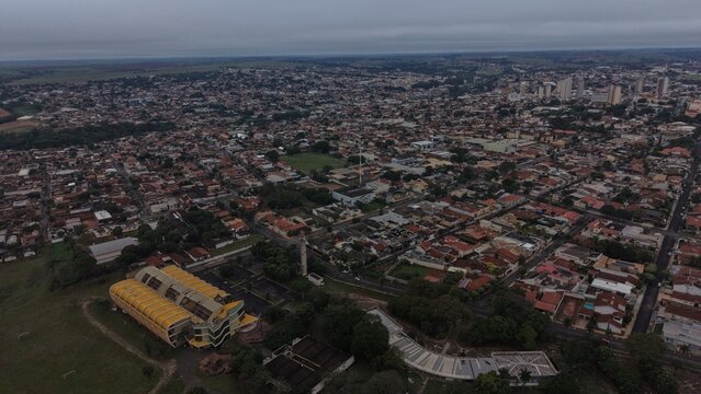 Aerial view of a sprawling suburban city with dense housing and modern buildings under a cloudy sky